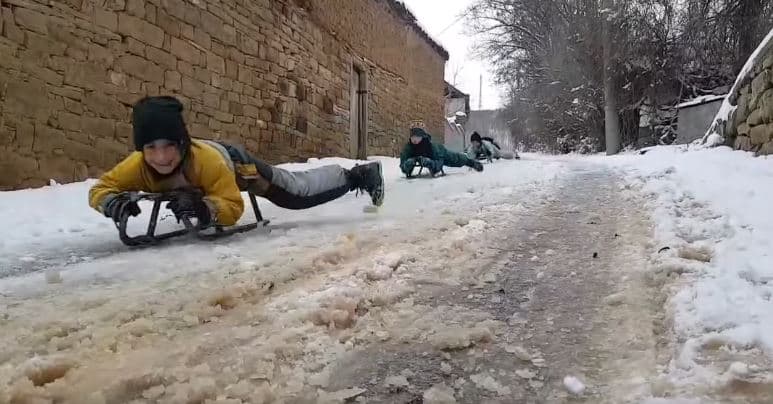 Fëmijët shijojnë borën, rrëshqasin me saja në Vidimriq të Mitrovicës (VIDEO)